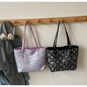 Detail of patterned tote bags in lavender and black with retro jacquard fabric textures