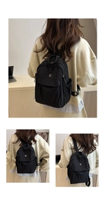 Close-up of black oxford cloth backpack with multiple zipper pockets and smooth texture