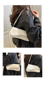 Detail of the white patent leather shoulder bag featuring a unique wavy flap and glossy finish