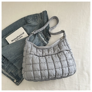Detail of light blue quilted cloud bag with adjustable strap and zipper closure