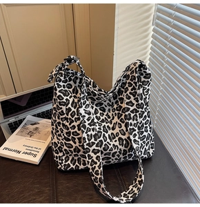 Detail of large leopard print canvas tote bag showing thick strap and durable texture