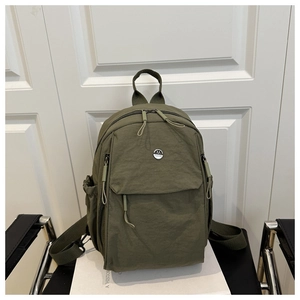 Detail view of military green nylon backpack featuring multi-pockets and M Fashion logo