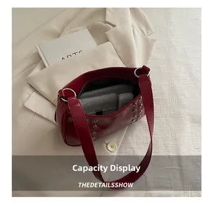 Capacity display of burgundy rivet shoulder bag with phone and wallet inside