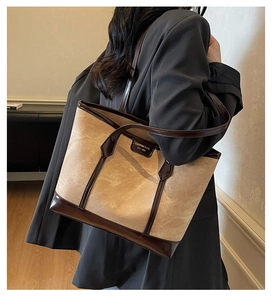 Détail du sac cabas minimaliste en daim beige avec bordures en cuir marron élégantes