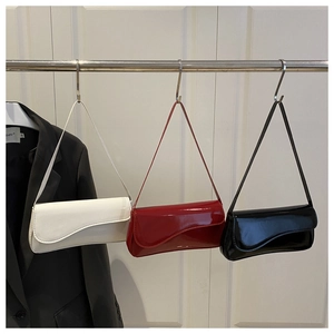 Glossy patent leather shoulder bags in white, red, and black with wavy flap detail