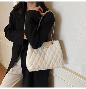 Détail du sac fourre-tout matelassé en velours blanc avec chaîne dorée et logo Labebu