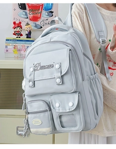 Side view of a light blue multi-pocket school backpack in a cozy study setting