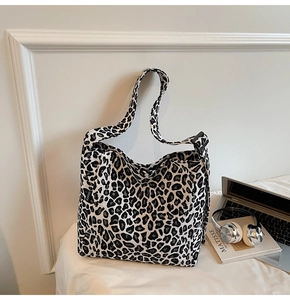 Detail of leopard print canvas tote bag featuring adjustable strap and fashion label