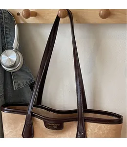 Vue détaillée de l'étiquette et des poignées en cuir marron du sac cabas en toile vintage