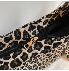 Close-up of leopard print canvas bag with textured weave and gold-tone metal zipper