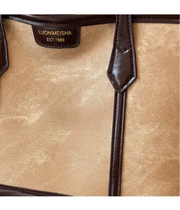 Détail de la toile et des coutures en cuir marron avec plaque de marque sur un cabas