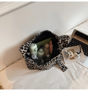 Macro shot showing high capacity of leopard print tote bag with laptop and daily essentials