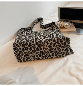 Detail of leopard print canvas tote bag with adjustable wide shoulder strap in daily setting