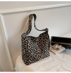 Detailed macro view of leopard print canvas tote bag with adjustable strap and fashion label