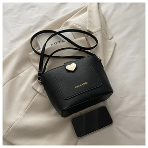 Vue détaillée du sac seau noir en cuir avec fermoir magnétique doré en forme de cœur