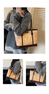 Détail du grand sac cabas beige marbré avec anses en cuir marron et plaque de marque en métal