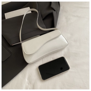 White glossy patent leather underarm bag shown next to a smartphone for size detail