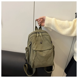 Olive green nylon backpack featuring multiple pockets and durable zippers for travel