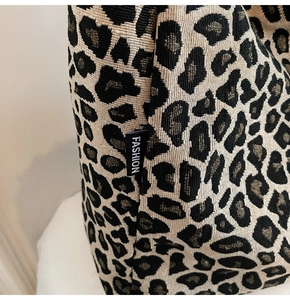 Close-up of leopard print canvas tote with a black Fashion woven label detail