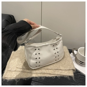 Detail of white leather shoulder bag with silver rivet studs and a smooth strap