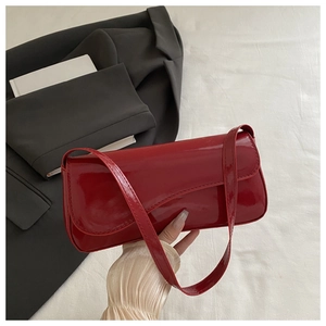 Detail of red patent leather shoulder bag with high-gloss finish and rectangular flap