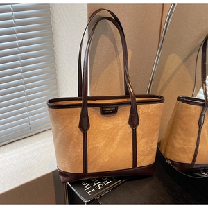 Détail du grand sac cabas rétro avec finitions en cuir contrasté et plaque de marque