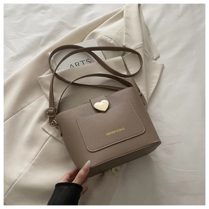 Vue détaillée du sac seau marron avec fermoir en cœur et texture en cuir grainé