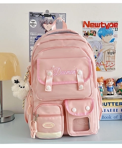 Pink multi-pocket school backpack detail with plush dog pendant and stylish laptop storage