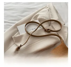 Detail of adjustable suede shoulder strap with high-quality metal buckle on tote bag