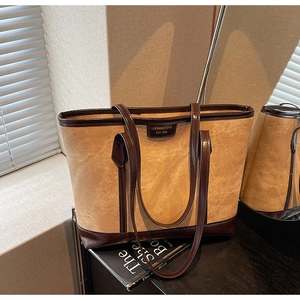 Détail du grand sac cabas vintage montrant le tissu marron texturé et le cuir foncé