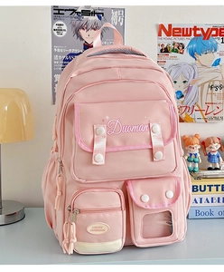 Detail view of pink multi-pocket nylon backpack with embroidery and white buckle accents