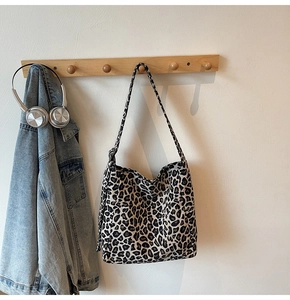 Detail shot of leopard print canvas tote bag texture and reinforced shoulder strap