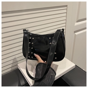 Detail of black glossy rivet shoulder bag with silver studs and sleek punk vintage style