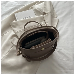 Vue de dessus du sac seau taupe montrant le cuir grainé et le grand espace intérieur