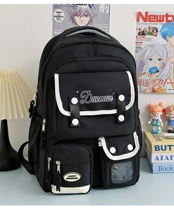 Close-up of black multi-pocket nylon backpack with white piping and logo detail