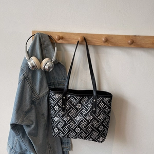 Classic black tote bag with white geometric embroidery and slim leather straps