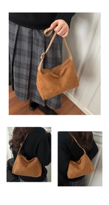 Detailed view of a brown suede tote bag featuring a zipper closure and adjustable strap