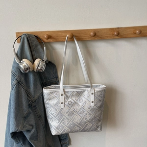 Chic white plaid tote bag with floral embroidery hanging on a wooden hook in a room