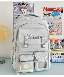 Detailed close-up of multi-pocket student backpack with silver strap and functional compartments