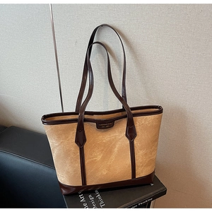 Détail du sac cabas vintage en toile kaki avec des finitions en cuir marron foncé