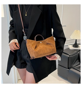 Detail of a brown leopard print tote bag styled with a professional black blazer suit