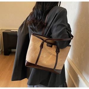 Détail du grand sac cabas marron porté à l'épaule avec logo doré élégant