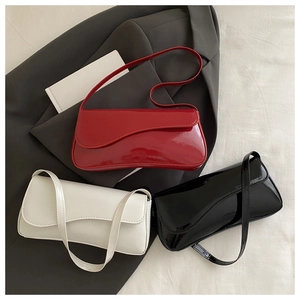 Detailed set of patent leather underarm bags in red, white, and black with asymmetric flaps