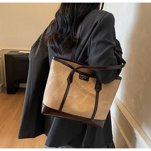 Détail du sac cabas kaki avec anses en cuir marron foncé et plaque de logo