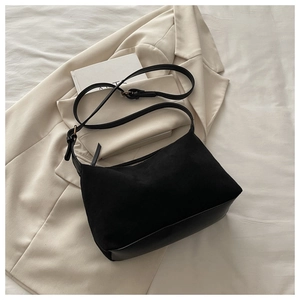 Close-up of black shoulder bag with matte suede splicing and silver zipper detail