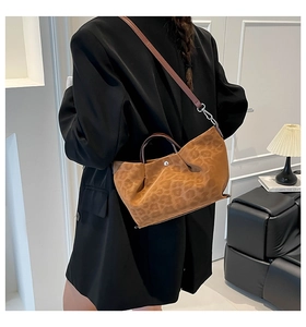 Detailed view of leopard print tote bag with leather straps and magnetic metal closure