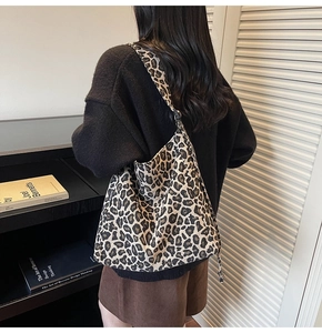 Detail of leopard print canvas tote bag with fashion label and woven texture on the side