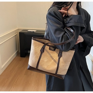 Détail du sac cabas en toile kaki avec garniture en cuir marron et logo de marque