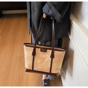 Détail d'un grand sac cabas rétro bicolore en toile beige et finitions en cuir