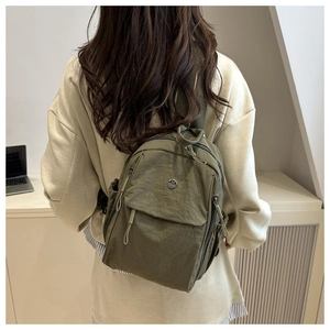 Army green nylon mini backpack shown from the back view on a model for daily use